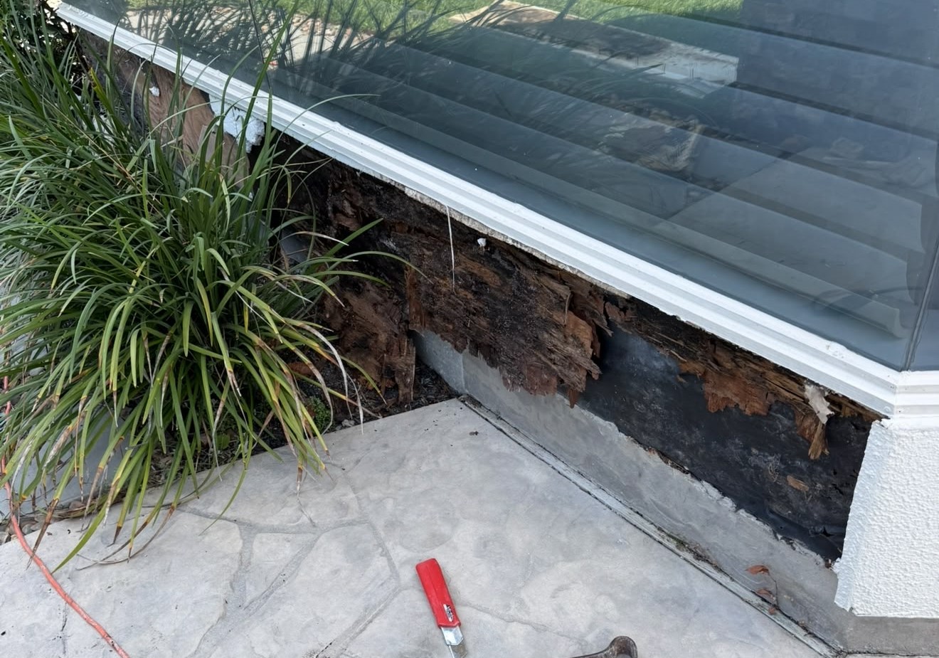 Concealed deterioration exposed at a window corner behind stucco cladding